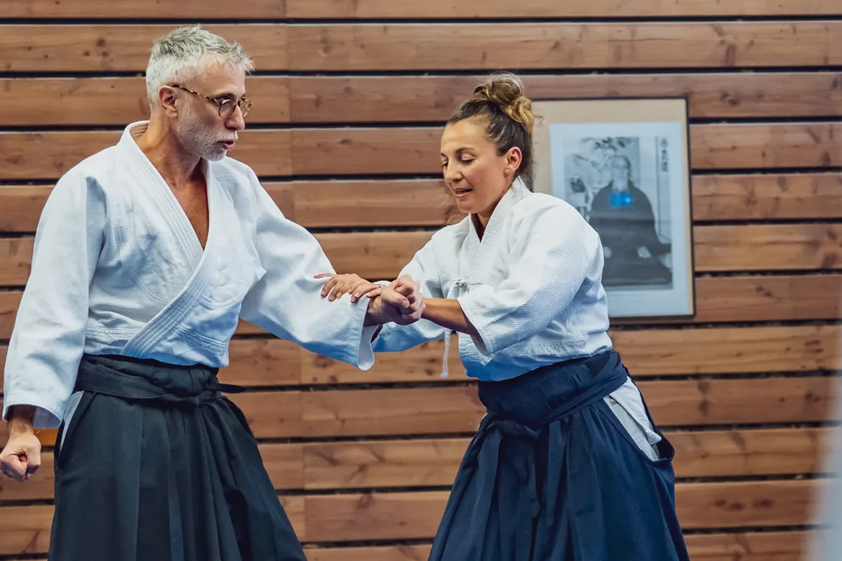 Deux pratiquants d'aïkido du dojo de Dardilly reliés par une saisie au poignet, en contact souple et attentif plutôt qu'en opposition
